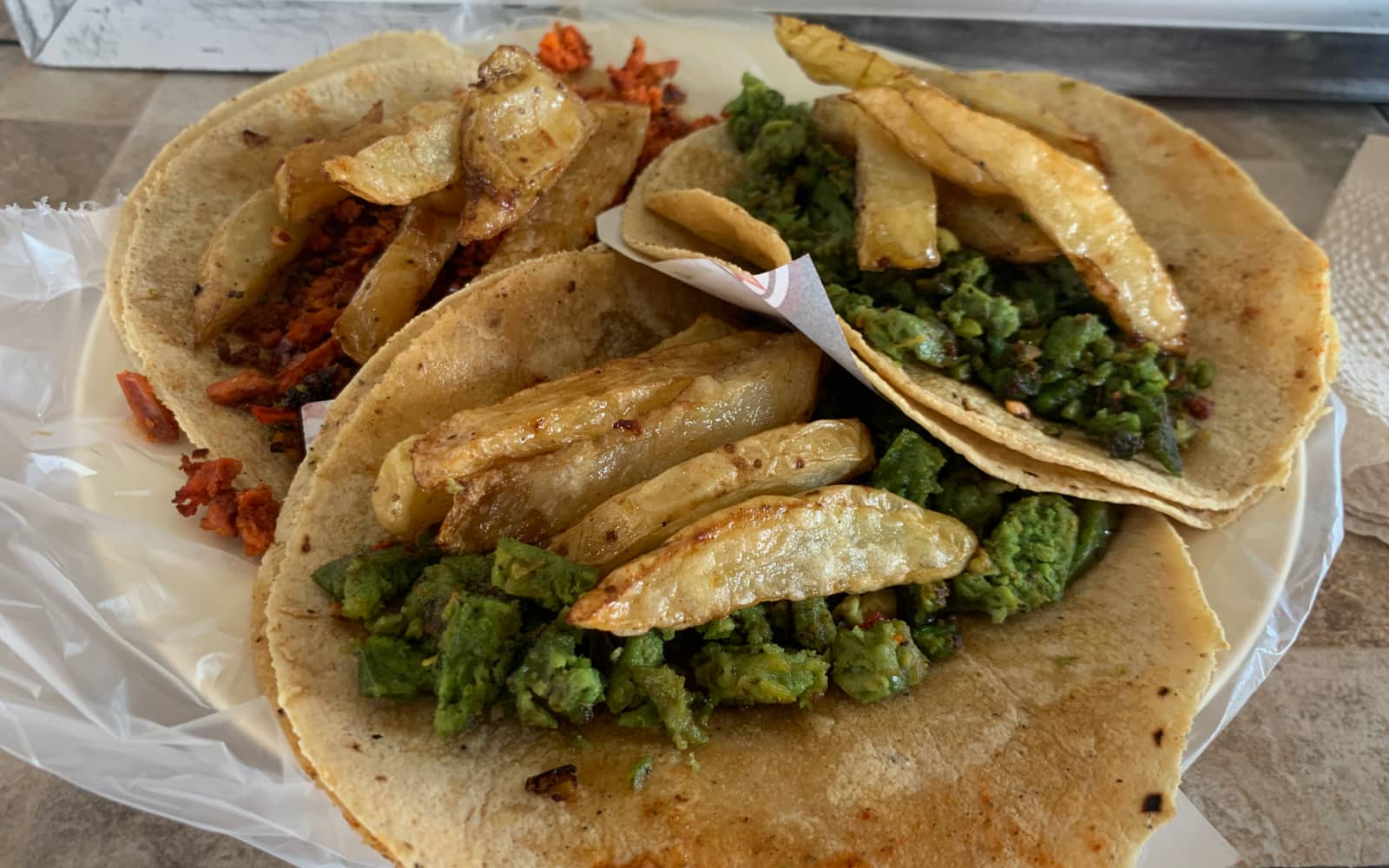 Green and red chorizo topped with fried potatoes served on corn tortillas